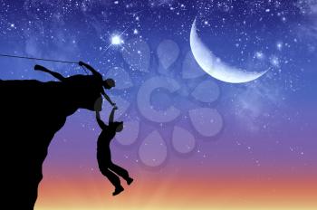Concept of aid. Silhouette of two climbers helping each other on the background of the moon at dawn