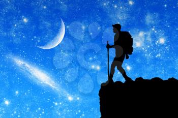 Concept of tourism and travel. Silhouettes of tourists in the mountains in the night sky