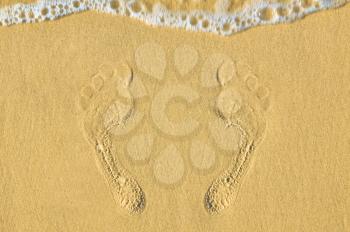 Human footprints on the sand at the beach. The concept of a beach holiday