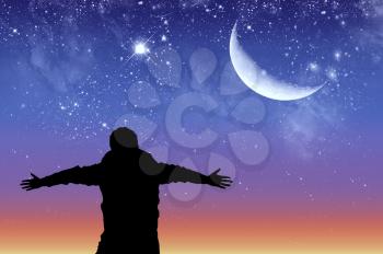 Concept of success. Silhouette of a happy man on the background of the starry sky and the moon