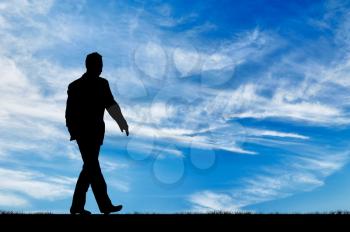 Silhouette of man walking on the background of the sunny sky