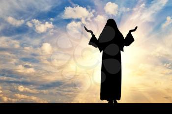 Concept of religion. Silhouette of nuns against the evening sky in the rays of light