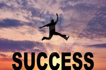Concept of success. Man jumping over the word success against the evening sky