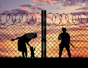 Concept of the refugees. Silhouette refugee mother with a baby and a border guard at sunset