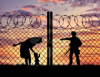 Concept of the refugees. Silhouette refugee mother with a baby and a border guard at sunset
