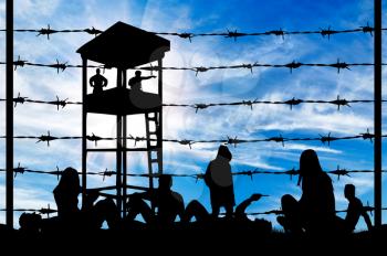 Concept of refugee. Silhouette of a crowd of refugees rest on the ground near the fence or barbed wire and watchtower