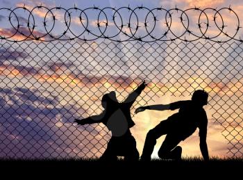 Concept of the refugees. Silhouette of refugees crossed the border illegally through the hole in the fence