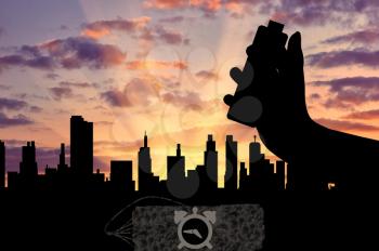 Concept of terrorism. Silhouette of a bomb with a detonator in his hand against the evening city
