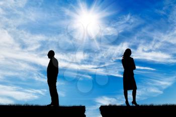 Concept of relationship. Silhouette of the gap between men and women in quarrel against the background of the sunny sky