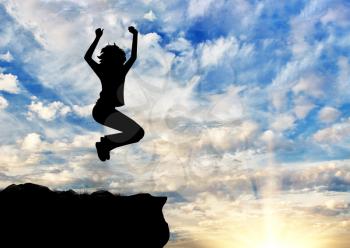 Concept of business success. Silhouette of a happy business woman jumping on top