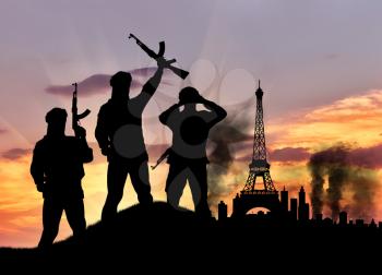 Concept of terrorism. Silhouette of the terrorists and the city in smoke against the sunset