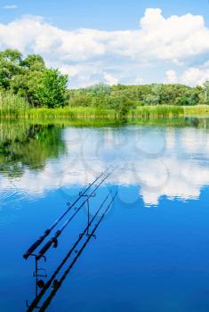 Concept of fishing and relaxation. Two fishing rods with a float on the background of beautiful scenery