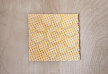 Crispy wafers in the shape of a square lies on a wooden surface