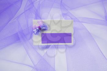 Concept of wedding accessories. Wedding cards lilac color on cloth background