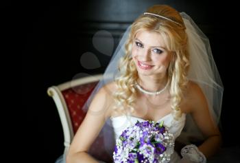 Wedding concept feelings and emotions. Beautiful and elegant bride smiling with a bouquet of flowers in the room sitting
