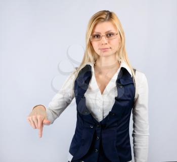 Concept of a reprimand and fall. Business woman in a suit shows thumb down