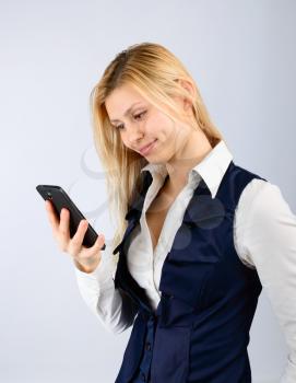 Business woman holding a smartphone in his hand on a light background