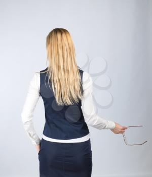 Business woman with glasses in her hand back on a light background