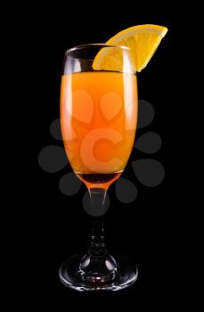 Mimosa cocktail with a slice of orange on a black background closeup