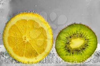 Slices of lemon and kiwi in water. design element