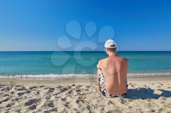 Young man resting on the beach. beach recreation and tourism concept