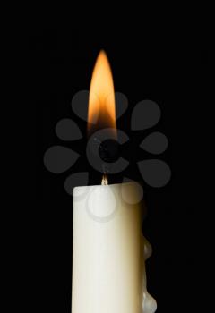 Burning white candle. Isolated on a black background