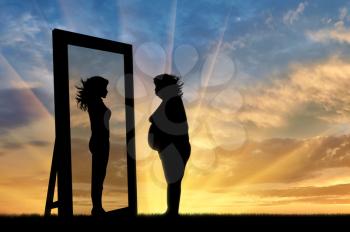 concept of fight against obesity and the desire to be slim. Silhouette thick and slender woman reflected in a mirror at sunset