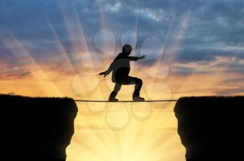 Man walks on a tightrope over a cliff. Concept of business risk