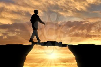 Man walking on man lying on precipice. Concept of social inequality