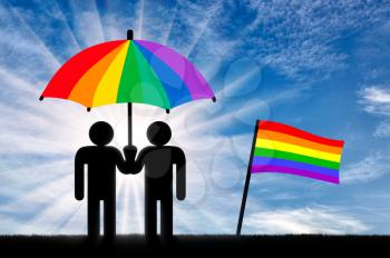 Two gay men under a rainbow umbrella near a rainbow flag against the sky