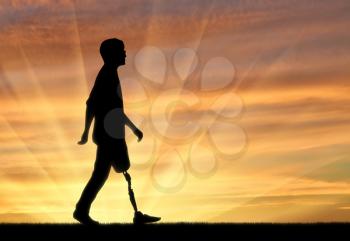 Walking disabled with a prosthetic leg at sunset