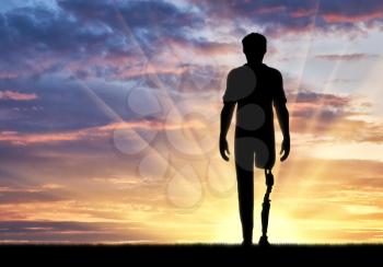 Disabled person with a prosthetic leg at sunset