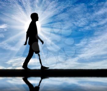 Walking disabled with a prosthetic leg against the sky and the river with its reflection