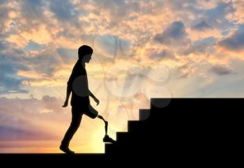 Disabled Walking with a prosthetic leg climbs the stairs at sunset