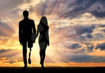 Concept of support and assistance to people with disabilities. Disabled person with a prosthetic leg, walking with a woman holding hands at sunset