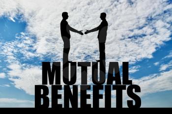 Silhouette two men are going to shake hands, standing on the word mutual benefit. The concept of mutual benefit in business