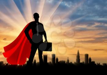 Superman businessman superhero. Silhouette of a confident and strong superman businessman with a briefcase on the background of the metropolis city, sunset