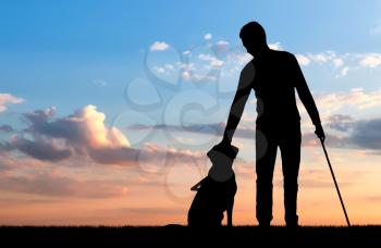 Silhouette of a blind disabled man stroking his dog guide. The concept of blind people with guide dog