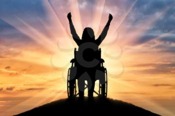 Happy disabled woman in wheelchair at sunset. The concept of happy people with disabilities