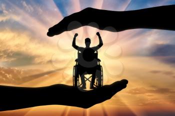 Happy disabled in wheelchair in hands of help. The concept of social protection and assistance to people with disabilities