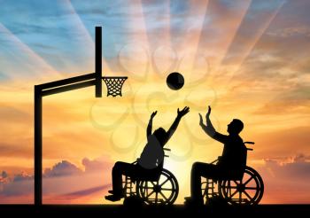 Two disabled people play wheelchair basketball in the open air. The concept of sports lifestyle people with disabilities