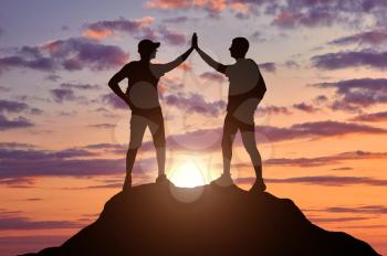Two happy climbers on top of a mountain. Conceptual image of success