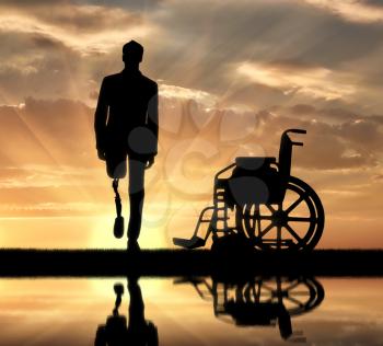 Disability and rehabilitation. Walking is a disabled man with a prosthetic leg and a wheelchair near the river