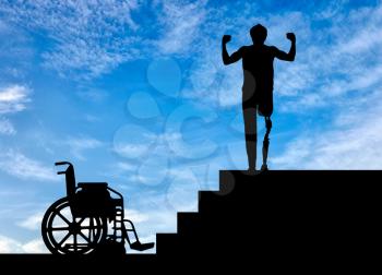 Disability and rehabilitation. Happy disabled man with a prosthetic leg walked up the stairs, and a wheelchair