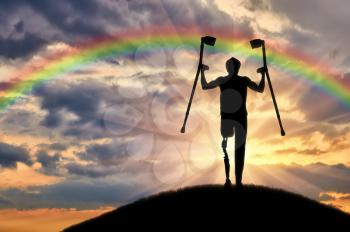 Happy a disabled person with a prosthetic leg holding crutches on a background of clouds and rainbows
