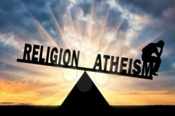 A frustrated man made a choice in favor of atheism and not religion on the scales. The concept of atheism and atheist
