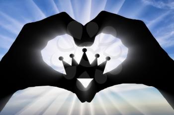 The hands of a man hold a crown, showing that he likes this symbol of the heart. Concept of narcissism