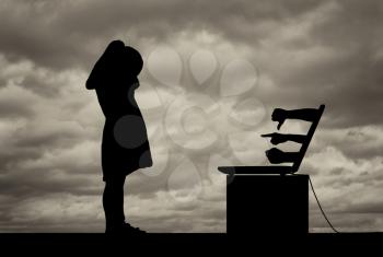 Girl child crying standing in front of a laptop, he shows her hands with negative gestures and threats against the background of a dramatic sky. Conceptual image of cyber bullying children