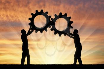 Silhouette of two men holding gears put them together in one gear. The concept of mutual funds