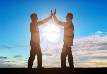 Silhouette of men make a gesture, give five. The concept of teamwork
